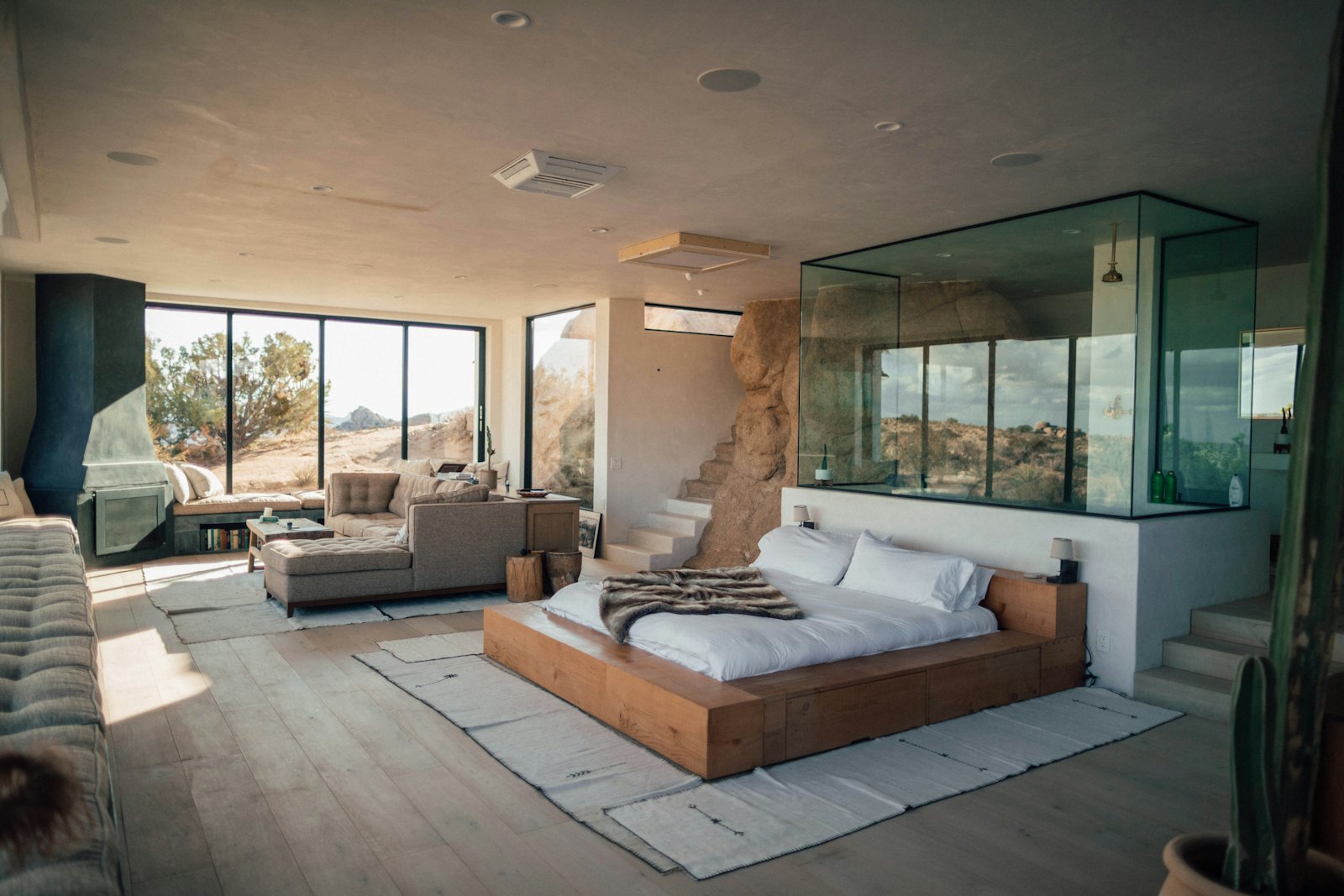 Chambre d’hôtel lumineuse avec grande baie vitrée donnant sur un paysage naturel