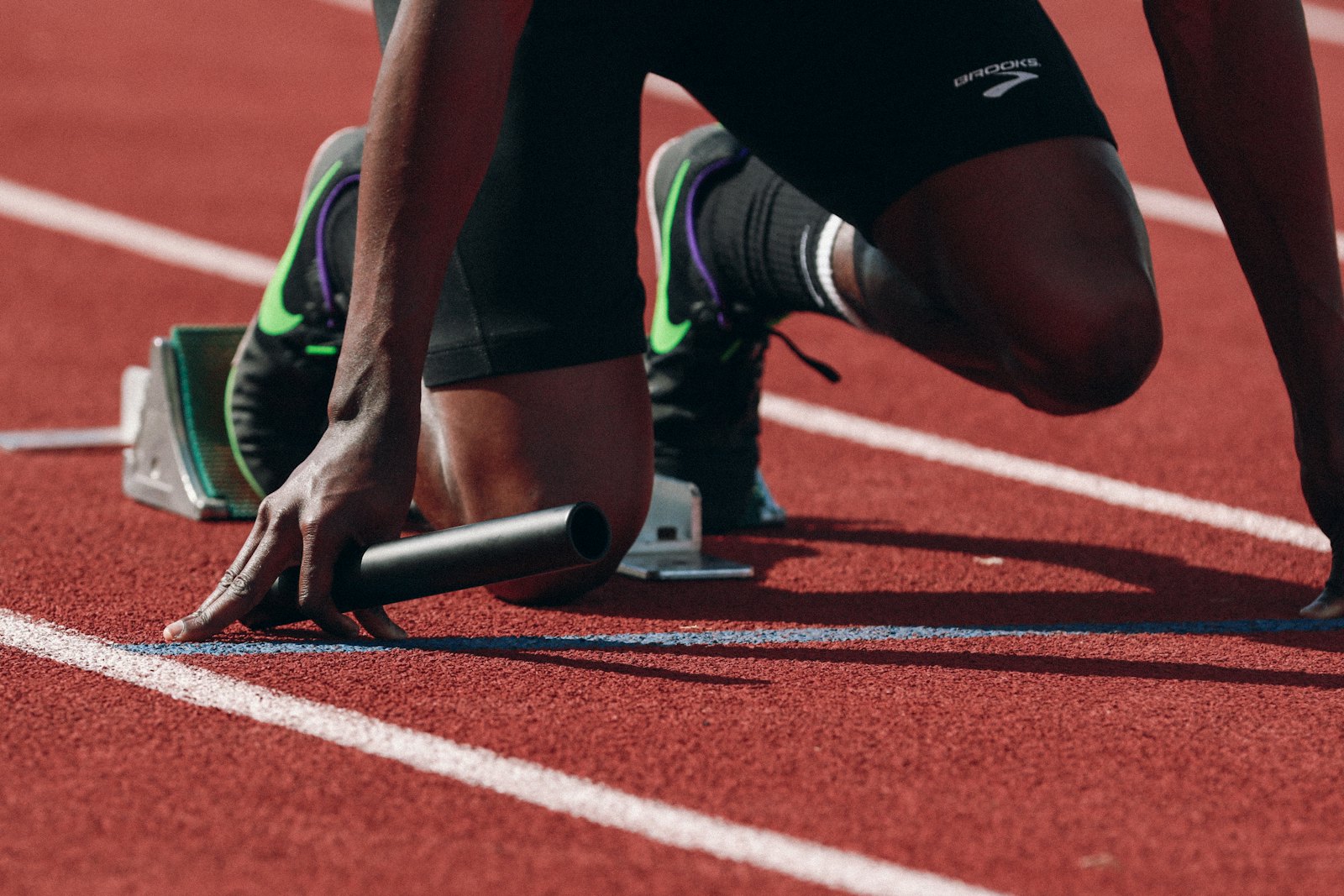 Athlète en position de départ sur une piste d’athlétisme rouge